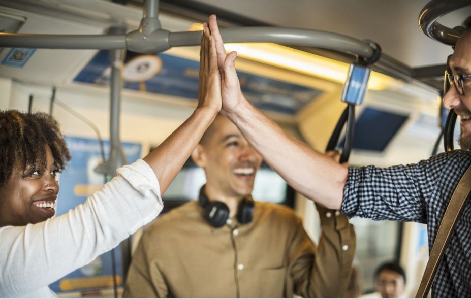 two people on a subway high-fiving